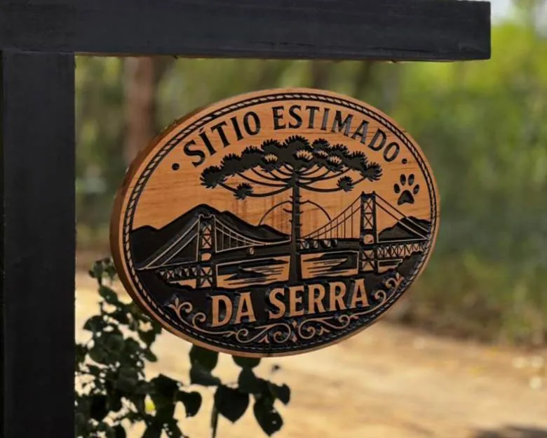 Placa de madeira no formato oval com nomes entalhados